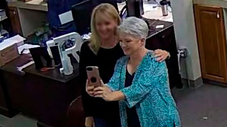 Cathy Latham, right, appears to take a selfie with a member of a computer forensics team inside the local elections office Pic:AP