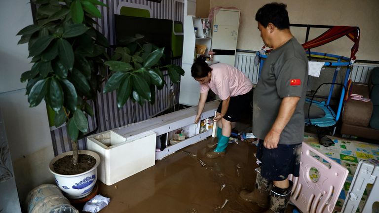 Wang Dan, 30, moves a cabinet with her father at her parents&#39; home, after rain and floods brought by remnants of Typhoon Doksuri, at a village in Zhuozhou, Hebei province, China August 7, 2023. REUTERS/Tingshu Wang
