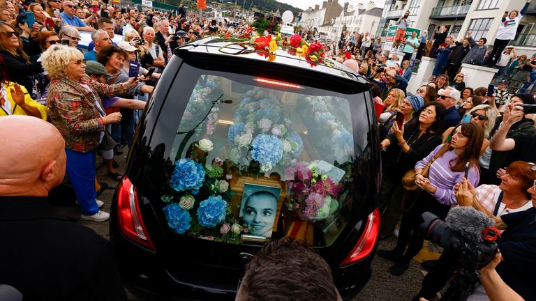 A hearse carrying the coffin of late Irish singer Sinead O&#39;Connor passes near her former home during her funeral procession as fans line the street to say their last goodbye to her, in Bray, Ireland, August 8, 2023. REUTERS/Clodagh Kilcoyne
