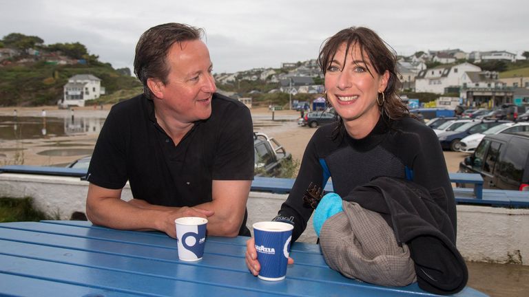 POLZEATH, ENGLAND - AUGUST 23:  British Prime Minister David Cameron and his wife Samantha have a coffee outside the Galleon Beach Cafe following an early morning swim in the sea during his holiday in the small seaside resort of Polzeath on August 23, 2015 in Cornwall, England.