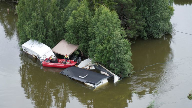 The fire service workers save belongings from caravans that have been swept away by the water following the extreme weather Hans, in Fagernes, in Norway