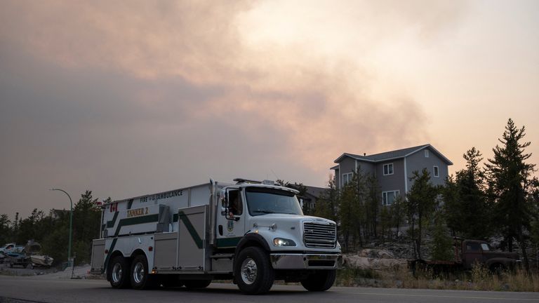 A Yellowknife Fire Department truck leaves a neighbourhood as smoke plumes near the city, a day after state of emergency was declared due to the proximity of a wildfire in Yellowknife, Northwest Territories, Canada August 15, 2023. REUTERS/Pat Kane
