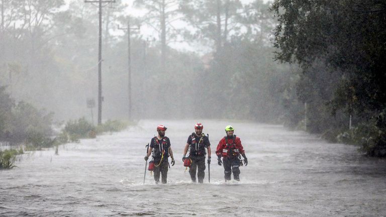 Rescue workers with Tidewater Disaster Response wade through a tidal surge on SW 358 Highway while looking for people in need of help after the Steinhatchee River flooded on Wednesday, Aug 30, 2023, in Steinhatchee, Fla., following the arrival of Hurricane Idalia. (Douglas R. Clifford/Tampa Bay Times via AP)