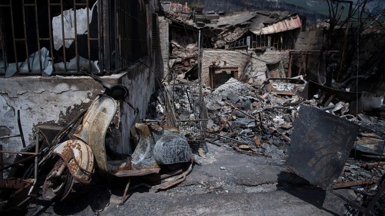 A burned scooter is seen in Acharnes suburb, on Mount Parnitha. Pic: AP