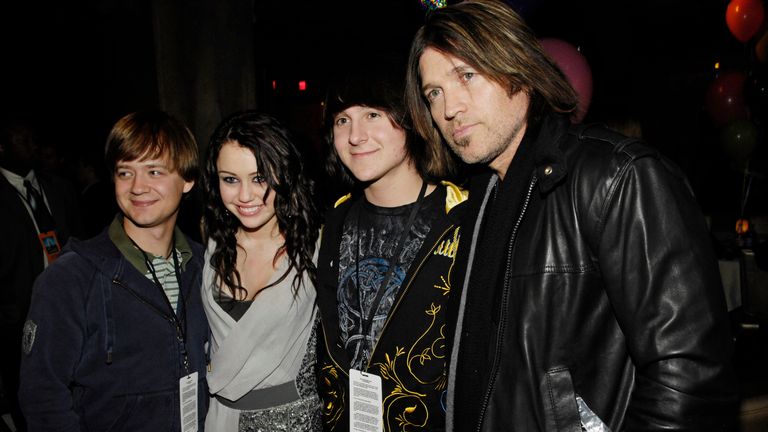Actress/singer Miley Cyrus, second from left, poses with fellow "Hannah Montana" cast members (L-R) Jason Earles, Mitchel Musso and her father Billy Ray Cyrus at the world premiere of the film "Hannah Montana & Miley Cyrus: Best of Both Worlds Concert" in Los Angeles, Thursday, Jan. 17, 2008. (AP Photo/Chris Pizzello)