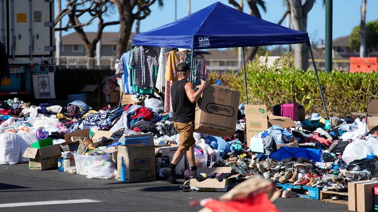 Donated clothes are gathered in a parking lot, Sunday, Aug. 13, 2023, in Lahaina, Hawaii, following heavy damage caused by wildfire in the area. (AP Photo/Rick Bowmer)