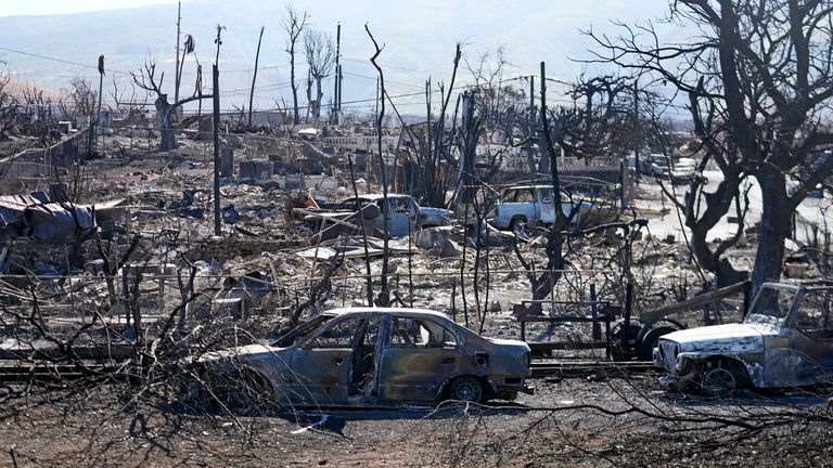 Destroyed homes and cars are shown, Sunday, Aug. 13, 2023, in Lahaina, Hawaii. Hawaii officials urge tourists to avoid traveling to Maui as many hotels prepare to house evacuees and first responders on the island where a wildfire demolished a historic town and killed dozens. (AP Photo/Rick Bowmer)