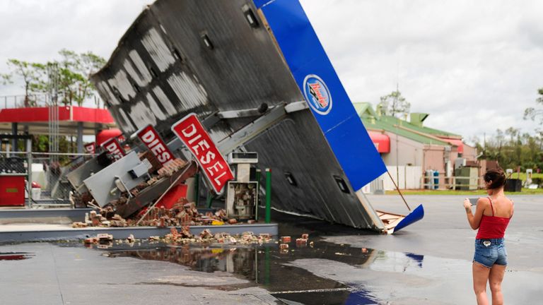 Hope Laird takes a photo of the wreckage of a gas station near her home after the arrival of Hurricane Idalia in Perry, Florida, U.S., August 30, 2023. REUTERS/Cheney Orr