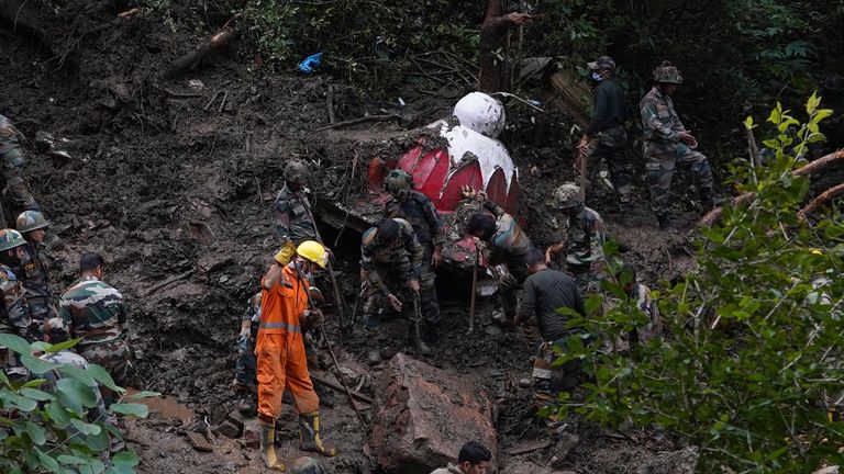 Rescuers search the debris for survivors after a landslide following heavy rainfall in Shimla, India 
Pic:AP