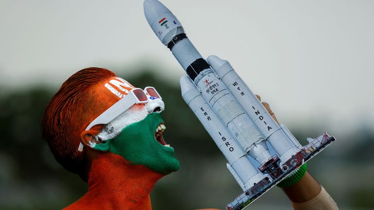 Arun Haryani, an enthusiast with his body painted in tri-colours reacts as he holds up a model of LVM3 M4 which was used in launching of Chandrayaan-3 spacecraft on the eve of its moon landing, in Ahmedabad, India, August 22, 2023. REUTERS/Amit Dave
