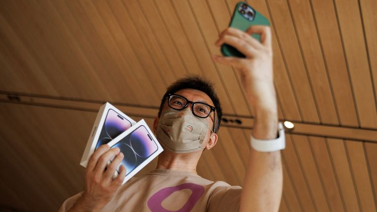 A man takes a selfie with two iPhone 14 as Apple Inc&#39;s new models go on sale at an Apple store in Beijing, China, September 16, 2022. REUTERS/Thomas Peter