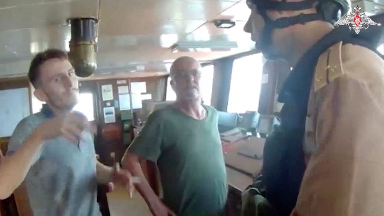 A still image from a video, released by Russia&#39;s Defence Ministry, shows what it said to be a Russian navy officer talking to a crew member during an operation to board the Palau-flagged Sukru Okan vessel with the help of a Ka-29 military helicopter in the Black Sea