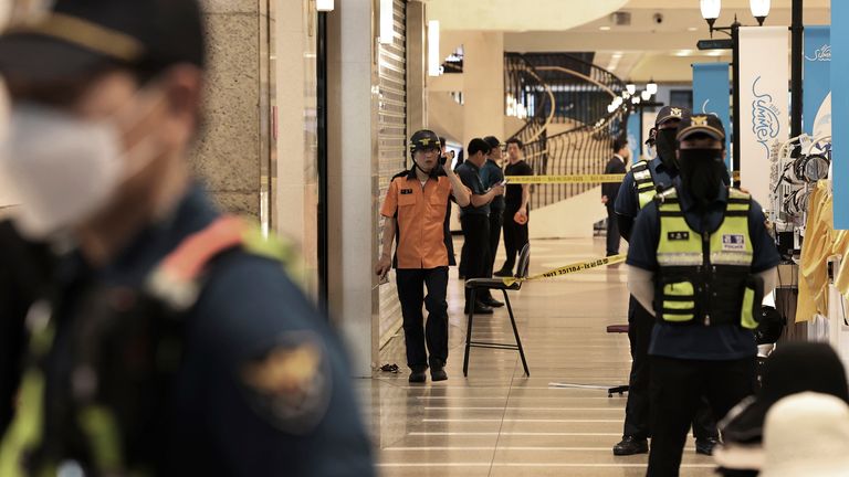 Police officers cordon off the scene of a stabbing rampage near a subway station in Seongnam, South Korea, Thursday, Aug. 3, 2023. A dozen of people were injured in South Korea on Thursday when a man rammed a car onto a sidewalk and then stepped out of the vehicle and began stabbing people near a subway station in the city of Seongnam.(Hong Hae-in/Yonhap via AP)