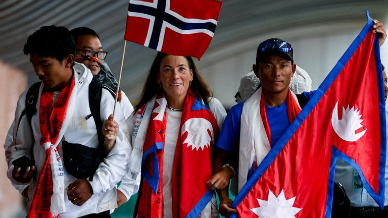 Norwegian mountaineer Kristin Harila, 37, and Nepali mountaineer Tenjen (Lama) Sherpa, 35, holding the flags of their countries, arrive at the airport after becoming the world&#39;s fastest climbers to scale all peaks above 8,000 meters in the shortest time, in Kathmandu, Nepal, August 5, 2023. REUTERS/Navesh Chitrakar TPX IMAGES OF THE DAY
