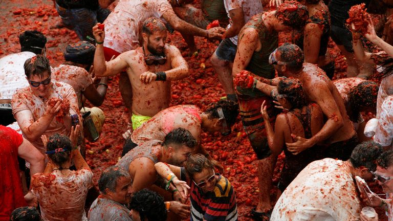 Revellers play in tomato pulp during the annual "La Tomatina" food fight festival in Bunol, Spain, August 30, 2023. REUTERS/Eva Manez

