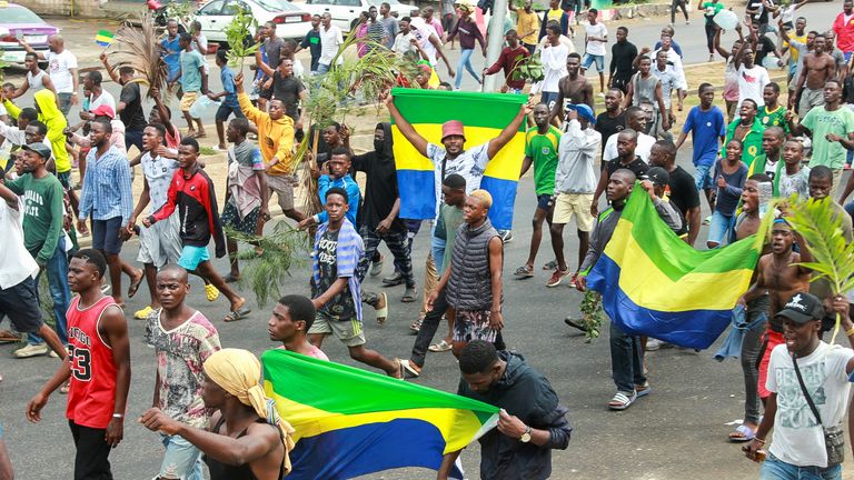 People celebrate on the streets of Libreville following the coup 
