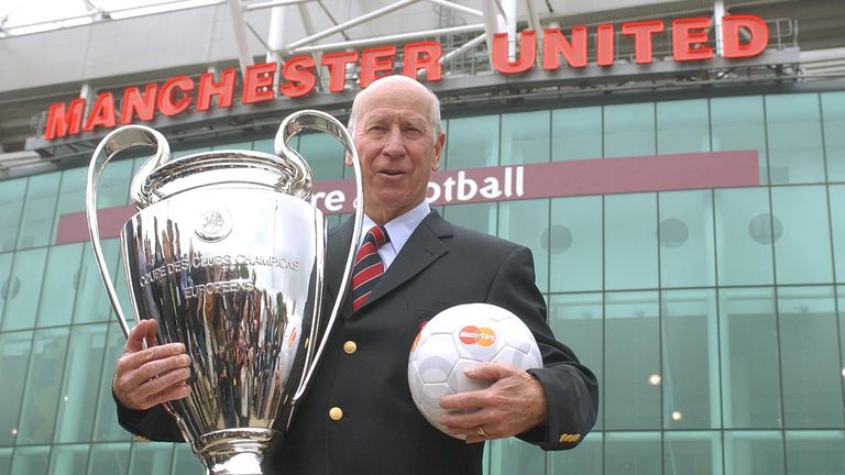 Manchester United oyuncusu Sir Bobby Charlton, Avrupa Kupası'nı Manchester United'ın Old Trafford binasının önünde tutuyor Pic:AP