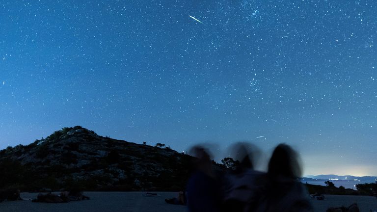 People watch as meteor streaks in the night sky during the annual Perseid meteor shower on the island of Lastovo, Croatia August 12, 2023. REUTERS/Antonio Bronic