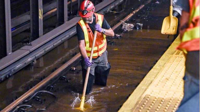 An MTA worker knee-deep in water on subway tracks from a water main break in New York&#39;s Times Square. Pic: AP