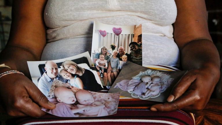 Mandy Sibanyoni, nanny of the three daughters of Graham and Lauren Dickason, holds photographs of the Dickason family back in 2021. Pic: AP