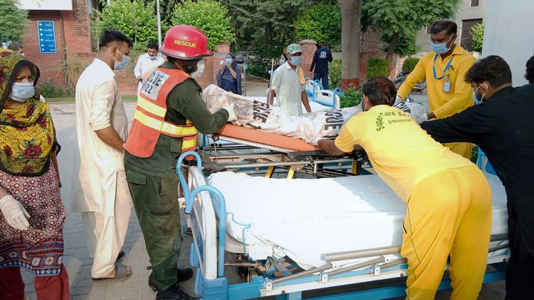 Hospital staff and rescue workers carry a victim of a bus accident. Pic: AP