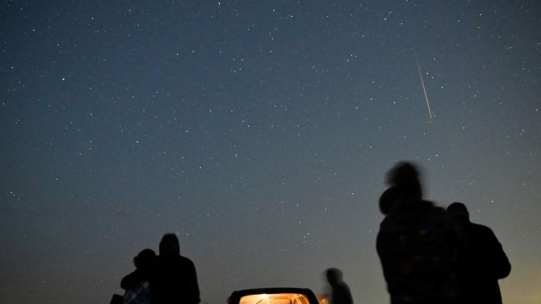 People watch as meteor streaks in the night sky during the annual Perseid meteor shower in the Siberian town of Yeniseysk in the Krasnoyarsk Region, Russia August 12, 2023. REUTERS/Alexey Malgavko