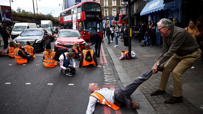 A member of the public dragging an activist who is blocking the road during a "Just Stop Oil" protest, in London. Pic: Henry Nicholls