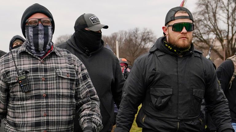 FILE - Proud Boys members Joseph Biggs, left, and Ethan Nordean, right with megaphone, walk toward the U.S. Capitol in Washington, Jan. 6, 2021. Former Proud Boys leader Enrique Tarrio and three other members of the far-right extremist group have been convicted of a plot to attack the U.S. Capitol in a desperate bid to keep Donald Trump in power after Trump lost the 2020 presidential election. (AP Photo/Carolyn Kaster, File)
