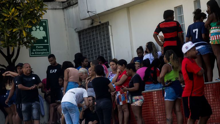 People wait outside a hospital for the arrival of victims of a Rio police raid. Pic: AP