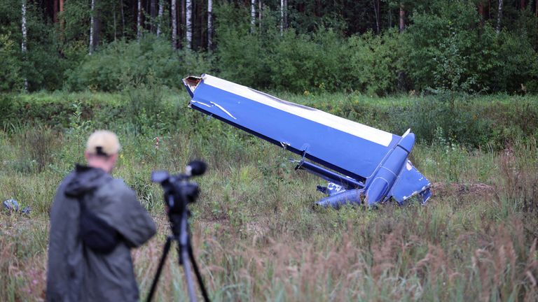 A cameraman films a wreckage of the private jet linked to Wagner mercenary chief Yevgeny Prigozhin near the crash site in the Tver region, Russia 
