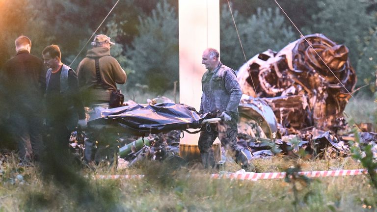 A body bag is carried away from the scene of the crash. Pic: AP