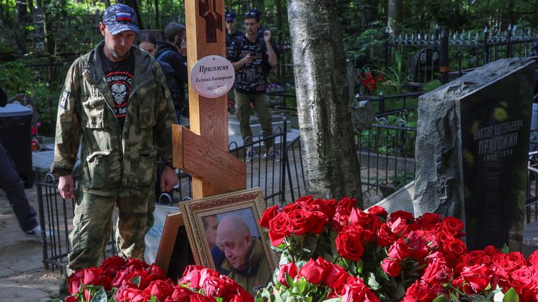 A man wearing a shirt with the logo of Wagner private mercenary group stands next to the grave of Russian mercenary chief Yevgeny Prigozhin at the Porokhovskoye cemetery in Saint Petersburg, Russia, August 30, 2023. REUTERS/Stringer
