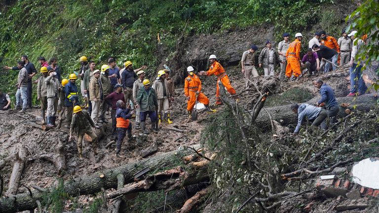 Rescuers remove mud and debris as they search for people feared trapped after a landslide near a temple on the outskirts of Shimla, Himachal Pradesh state, Monday, Aug.14, 2023. Heavy monsoon rains triggered floods and landslides in India&#39;s Himalayan region, leaving more than a dozen people dead and many others trapped, officials said Monday. (AP Photo/ Pradeep Kumar)