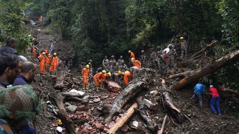 Rescuers search the debris for survivors after a landslide following heavy rainfall in Shimla, India 
Pic:AP
