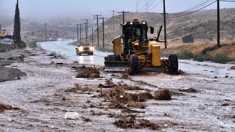 A plow clears debris along a flooded Sierra Highway in Palmdale, Calif., as Tropical Storm Hilary moves through the area Pic:AP