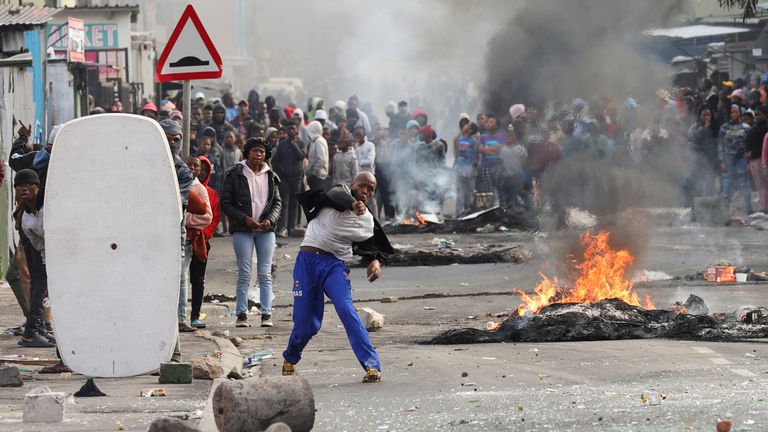 Residents of Masiphumelele throw bottles at law enforcement officers amidst an ongoing strike by taxi operators against traffic authorities in Cape Town, South Africa, August 8, 2023. REUTERS/Esa Alexander