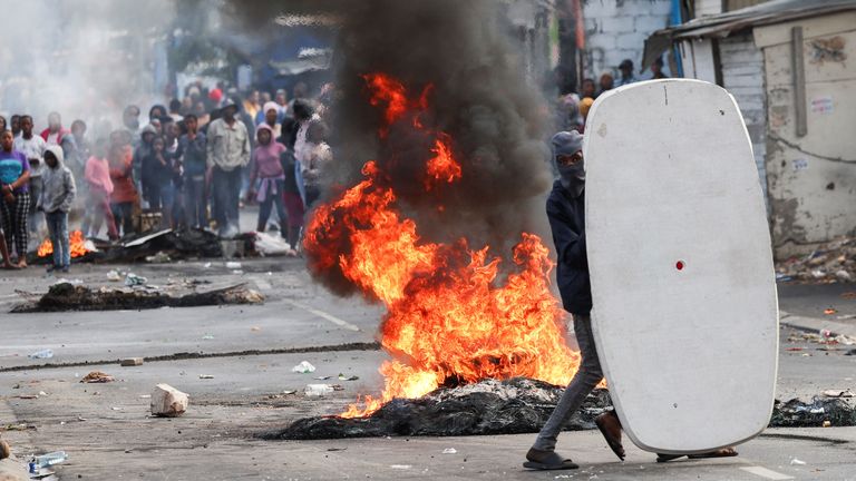 Residents of Masiphumelele throw bottles at law enforcement officers amidst an ongoing strike by taxi operators against traffic authorities in Cape Town, South Africa, August 8, 2023. REUTERS/Esa Alexander