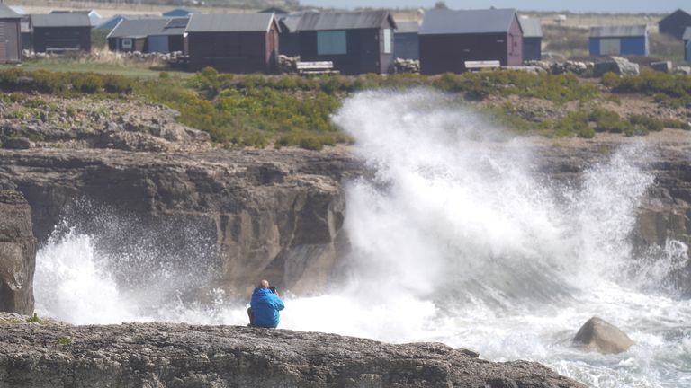 A man photographs waves crashing against the shore in Portland, Dorset, as Storm Antoni is set to bring "unseasonably strong" winds and heavy rain to the UK. Picture date: Saturday August 5, 2023.

