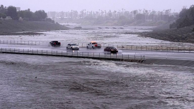 Vehicles cross over a flood control basin in Palm Desert, California. Pic: AP