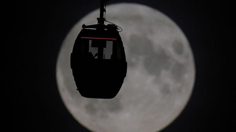 People view the super blue moon as they travel in a IFS Cloud Cable Car at Greenwich