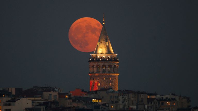 The super blue moon rises behind the Galata Tower in Istanbul, Turkey