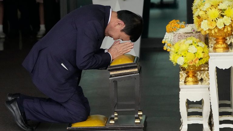 Thailand's former Prime Minister Thaksin Shinawatra prays in front of a portrait of King Maha Vajiralongkorn upon his arrival at Don Muang Airport in Bangkok, Thailand, Tuesday, August 22, 2023. (AP Photo/Sakchai Lalit)