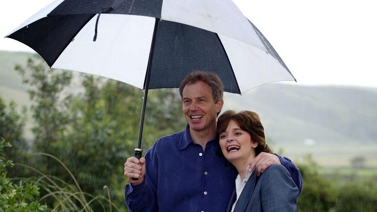 Prime Minister Tony Blair and his wife, Cherie, shelter under an umbrella at St Bees in Cumbria where they took a break from their holiday with their children to meet the media. *......They are expected to stay in the county, which is still recovering from the devastating effects of last year&#39;s foot and mouth disease, until Sunday before going to France for two weeks.