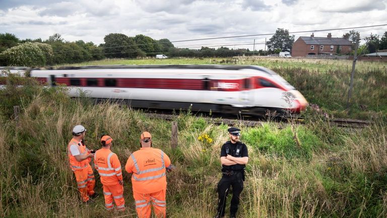 Police and railway workers near the scene in Balderton, near Newark-on-Trent. A police officer is in a serious condition after being hit by a train while trying to save a distressed man who was on the tracks. Nottinghamshire Police said officers were deployed to a residential area in Balderton just before 7pm on Thursday, over concerns for a man&#39;s safety. Picture date: Friday August 25, 2023.
