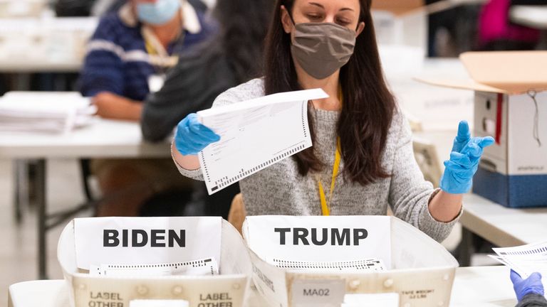 A Georgia election worker places a ballot in a counted bin during a hand recount of presidential votes on 15 Nov 2020 Pic: AP