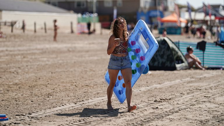 Beachgoers in Camber Sands enjoying the warm weather