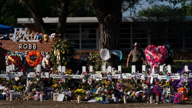 FILE - Flowers and candles are placed around crosses on May 28, 2022, at a memorial outside Robb Elementary School in Uvalde, Texas, to honor the victims killed in the school shooting. The teenage cousin of the gunman responsible for deadly school shooting in Uvalde, Texas, has been arrested Monday, Aug. 7, 2023, after his family told police he was trying to buy a gun and ...do the same thing,... court records show. (AP Photo/Jae C. Hong, File)