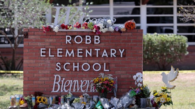 A general view of flowers and candles are placed around a welcome sign outside Robb Elementary School, Wednesday, May 25, 2022, in Uvalde, Texas. President Joe Biden mourned the killing of 19 children and two teachers in a mass shooting at a Texas elementary school on Tuesday. (Aaron M. Sprecher via AP)