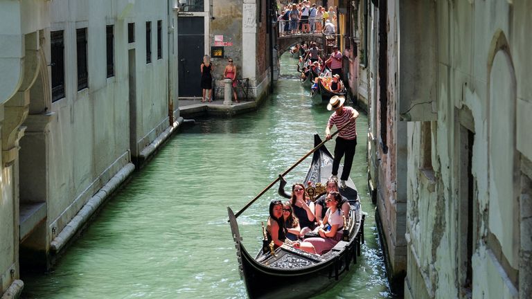 FILE PHOTO: Gondoliers row their gondolas through the Venice Canal as the city prepares for the Redentore Festival celebrations in Venice, Italy, July 15, 2023. REUTERS/Manuel Silvestri/File Photo
