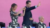 Bashar al Assad waves at the ceremony with his wife, Asma al Assad, beside him. Pic: AP